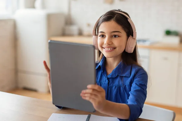 电子学习研究 一个快乐的小学生女孩带着数码平板电脑 上网和在家上网学习的肖像 中东女学生在室内用电脑和耳机学习 — 图库照片
