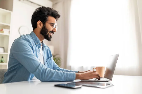 Smiling Indian Male Writer Using Laptop While Working Home Office — Stock Photo, Image