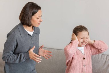 Katı, hüzünlü bin yıllık beyaz kadın, genç kızını azarlıyor, kulaklarını elleriyle kapatıyor, oturma odasının içinde çıldırıyor. Tartışma, disiplin, ilişki sorunları, evde stres