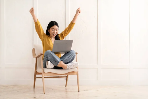 Счастливая Молодая Китаянка Повседневной Одежде Сидит Дома Кресле Пользуется Ноутбуком — стоковое фото
