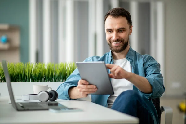 Freelancer Guy Χρησιμοποιώντας Ψηφιακή Ταμπλέτα Ενώ Κάθεται Στο Γραφείο Στο — Φωτογραφία Αρχείου