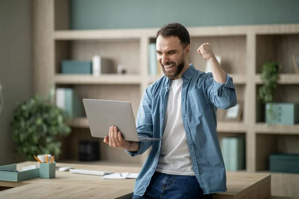 Başarı Genç Mutlu Adamı Ofiste Dizüstü Bilgisayarla Başarıyı Kutluyor Aşırı — Stok fotoğraf