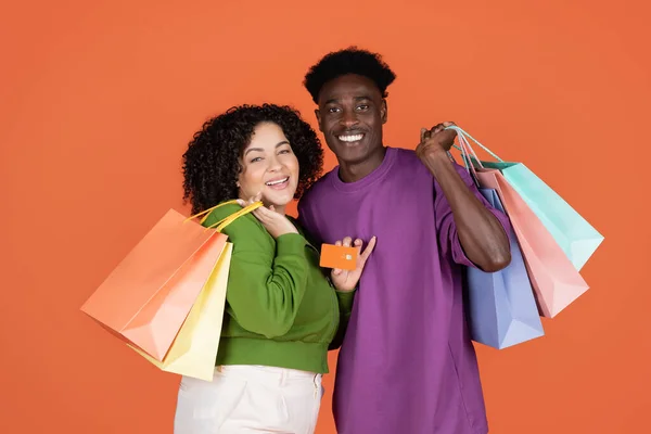 Glückliche Fröhliche Junge Multiethnische Paar Mit Bunten Einkaufstaschen Und Bankkarte — Stockfoto