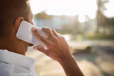 Cep telefonuyla konuşan genç işadamının yakın plan fotoğrafı, tanınmayan bir girişimcinin telefonla konuşması, kesilmiş görüntü, boş alan.