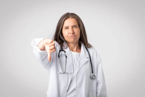 Mal Servicio Doctora Senior Bata Blanca Con Estetoscopio Mostrando Pulgar —  Fotos de Stock