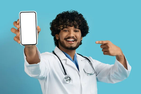 온라인 의료계 남자가 스크린을 전화기를 가리키며 스튜디오 배경에 고립되어 의사를 — 스톡 사진
