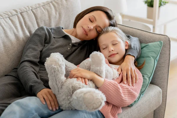 ソファの上でおもちゃの睡眠で十代の娘を抱きしめる千年紀の白人女性を疲れ リビングルームのインテリアで余暇をお楽しみください 快適さ 一緒にリラックス 家での関係と愛 — ストック写真