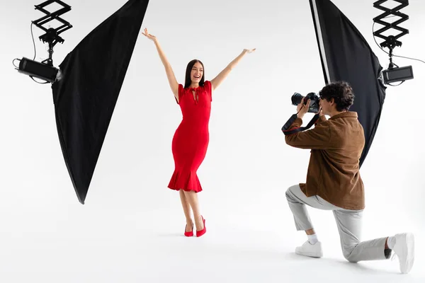 在摄影镜头后面 优雅的女模特为专业时尚摄影师摆姿势 拍摄背景为白色 时尚杂志摄影 — 图库照片