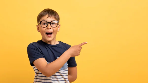 Nadšený Šťastný Školák Neformálním Tričku Brýlích Ukazující Kopírovací Prostor Pro — Stock fotografie