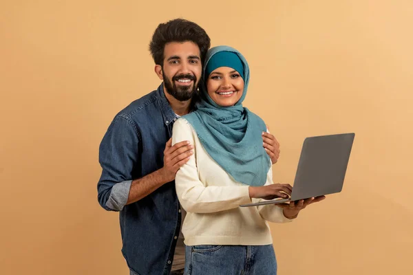 Portrét Šťastný Mladý Muslim Pár Notebookem Rukou Držení Béžovém Pozadí — Stock fotografie