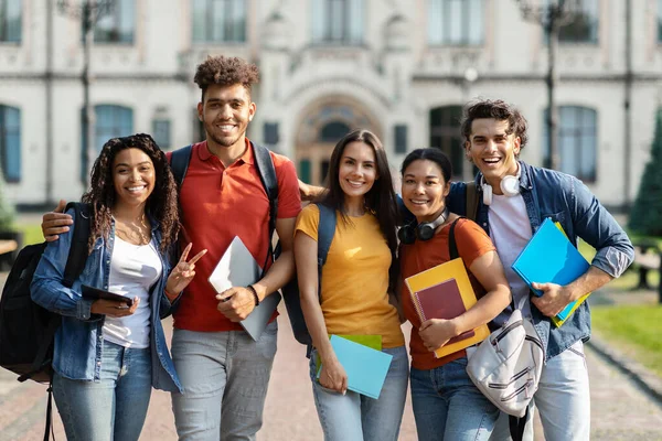 一群快乐的国际学生站在大学近旁摆姿势 一群快乐的多种族年轻人背着背包和练习本站在校园外 微笑着拥抱着 — 图库照片