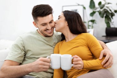 Aşk, ilişkiler. Neşeli, mutlu, güzel, aşık, İspanyol asıllı genç adam ve kadın gündelik olarak kanepede oturuyor, çay ya da kahve içiyor, sarılıyor, kocasını öpüyor, evde birlikte vakit geçiriyor.