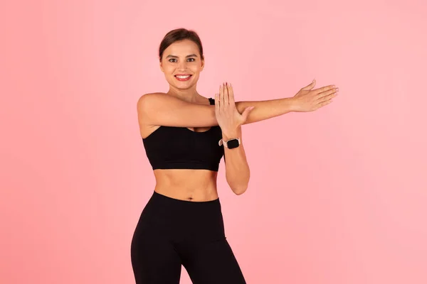 Smiling Fit Lady Abbigliamento Sportivo Braccia Stretching Mentre Posa Sfondo — Foto Stock