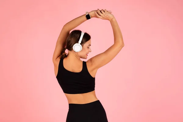 Smiling Young Sporty Woman Wearing Wireless Headphones Making Stretching Exercises — Stock Photo, Image