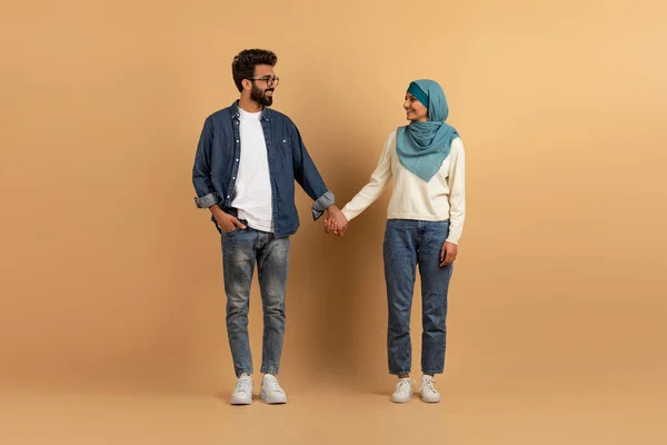 若いですムスリムカップル笑顔と見ますお互い ロマンチックな愛アラビア語男と女でハイジャブボンディング一緒に上のベージュスタジオ背景 コピースペース — ストック写真