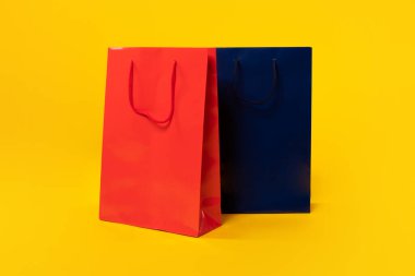 Mesaj, logo ya da tasarım için sarı stüdyo arka planı, maketi, kopyalama alanı olan iki büyük alışveriş torbası. Promosyon, teklif, sezon satışları, Kara Cuma konsepti.