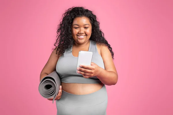 Smiling Black Chubby Woman Sportswear Mat Chatting Smartphone Standing Pink — Stock Photo, Image