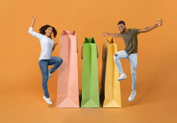 Consumerism Joyful Shopaholics Black Couple Jumping Posing Large Paper Shopping — Stock Photo, Image