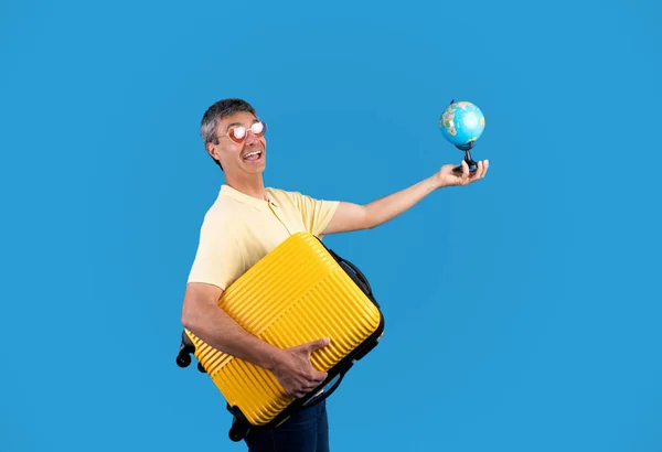 Globetrotter Fröhlicher Älterer Reisender Mit Weltkugel Und Gelbem Reisekoffer Posiert — Stockfoto