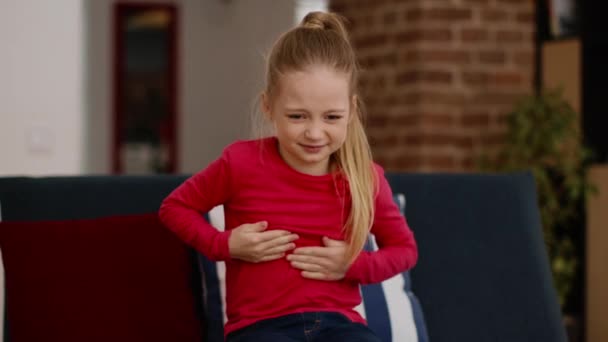 子供と医療の概念 自宅で胃の痛みに苦しんでいる動揺の女の子 彼女の腹と痛みをマッサージ 撮影を追跡 フリースペース — ストック動画