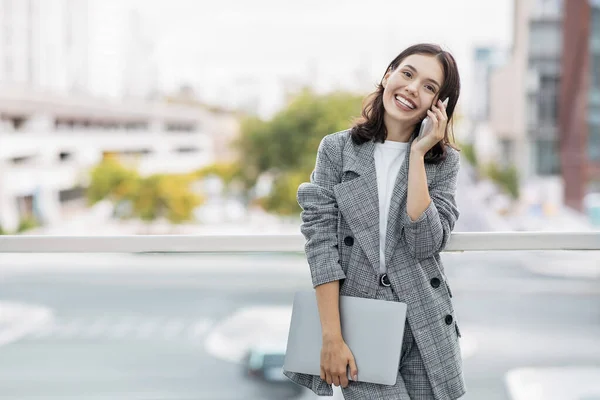 Happy Young Business Woman Μιλώντας Στο Τηλέφωνο Κρατώντας Φορητό Υπολογιστή — Φωτογραφία Αρχείου