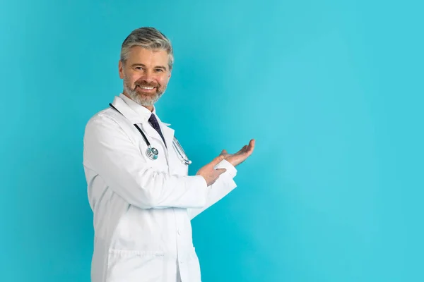 Χαμογελώντας Όμορφος Μεσήλικας Γιατρός Δείχνει Χώρο Των Αντιγράφων Για Διαφήμιση — Φωτογραφία Αρχείου