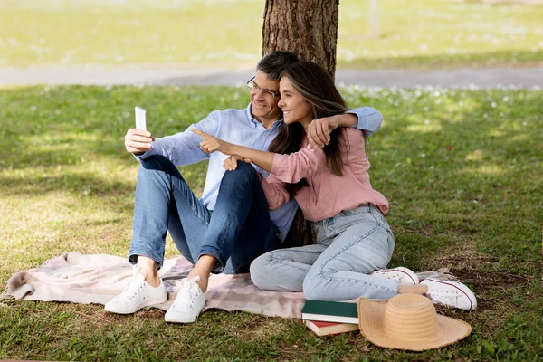 Smiling Middle Aged Couple Using Smartphone While Relaxing Summer Park — Stock Photo, Image