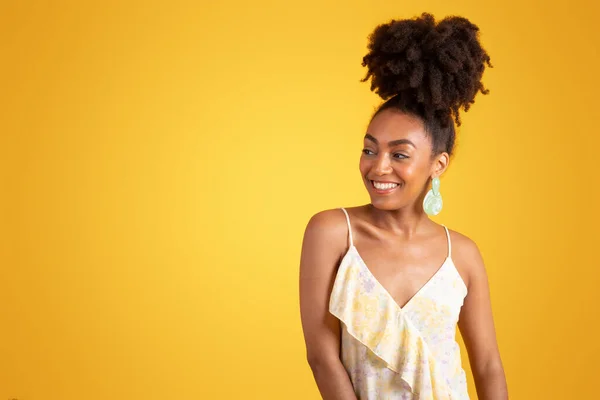 快乐漂亮的年轻的非洲裔美国女人穿着衣服看着空旷的空间 孤立在黄色的工作室背景下 时尚风格 广告和服务 生活方式 美容护理 — 图库照片
