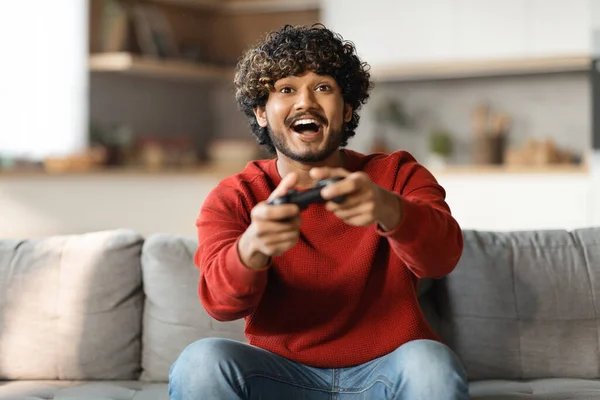 Νεαρός Ευτυχισμένος Ινδιάνος Που Γελάει Και Παίζει Βιντεοπαιχνίδια Σαββατοκύριακο Κάθεται — Φωτογραφία Αρχείου