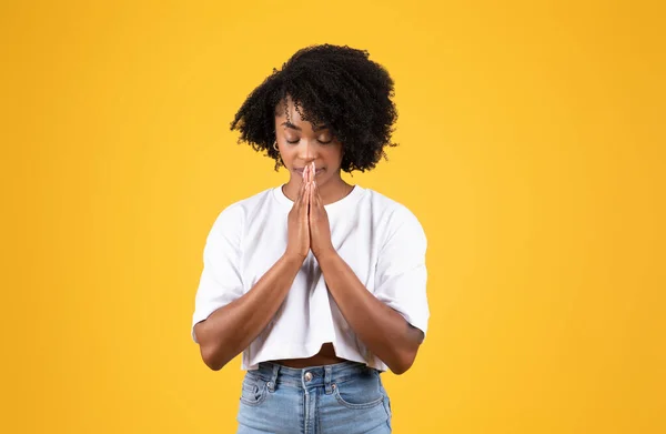 严重的千年黑人妇女在随意做祷告手势与手 孤立在橙色工作室的背景 愿望实现 人类的情感 生活方式 广告和服务 — 图库照片