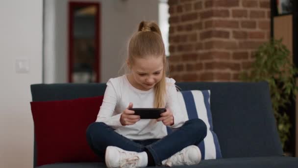 Современные Детские Развлечения Возбужденная Маленькая Девочка Играющая Видеоигры Смартфоне Выигрывающая — стоковое видео
