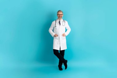 Mavi arka planda gözlük takan, el ele tutuşan ve kameraya gülümseyen neşeli, yakışıklı, gri saçlı, olgun sakallı bir doktor. Sağlık personeli
