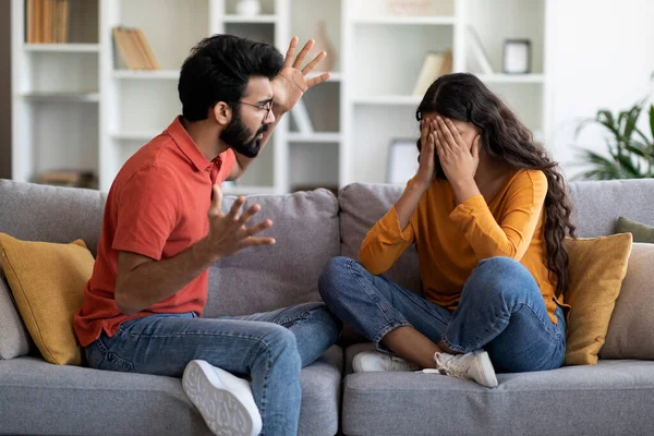 夫妻冲突 焦虑的年轻女人在家里哭泣 与丈夫争吵 年轻的印度家庭遭受感情危机 愤怒的男人在客厅里动情地谈论妻子 — 图库照片