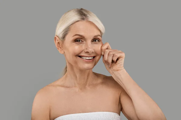 Koncepcja Ujędrniania Skóry Piękna Seniorka Dotykająca Twarzy Uśmiechnięta Aparatu Atrakcyjna — Zdjęcie stockowe