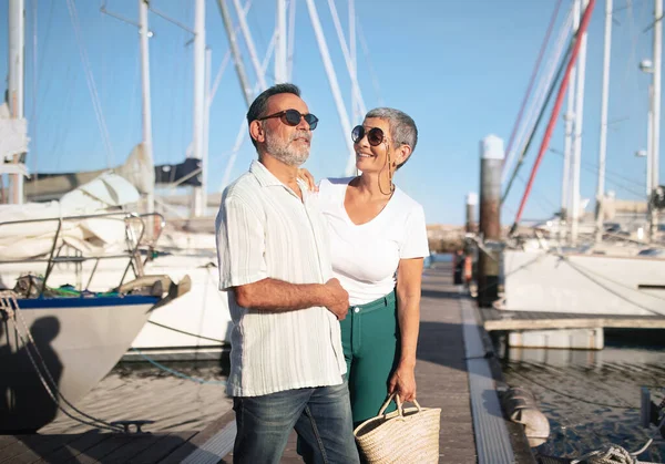 stock image Senior Sailboat Owners Couple Smiling And Hugging Standing Near Yachts At Marina Port, Posing Expressing Positive Emotions. Spouses Ready For Sea Cruise, Enjoying Summer Vacation Together