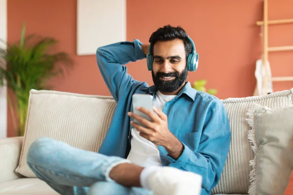 Musik För Avslappning Leende Mellanösternman Hörlurar Hålla Smartphone Och Njuta — Stockfoto