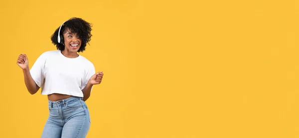 快乐的千年黑人妇女在休闲和无线耳机跳舞 喜欢听音乐 孤立在橙色工作室背景 音频应用 广告和提供 业余爱好 — 图库照片