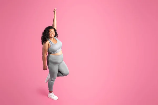 スポーツウェアを着たアフリカ系アメリカ人のプラスサイズの女性は ピンクの背景 完全な長さ 無料のスペースに孤立立って ワークアウトの結果を楽しんでいます ボディケア スポーツ広告 オファー フィットネス ピラティスやヨガ — ストック写真