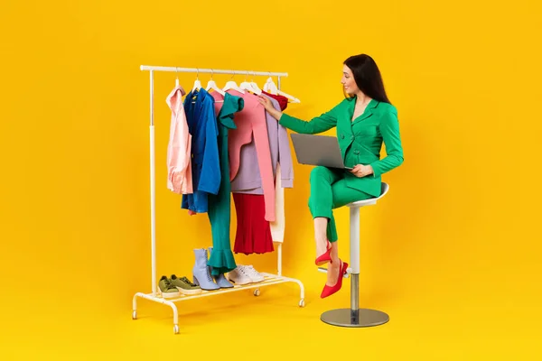 Dizüstü Bilgisayarı Olan Mutlu Bir Moda Tasarımcısı Warbrobe Rafındaki Kıyafetlere — Stok fotoğraf