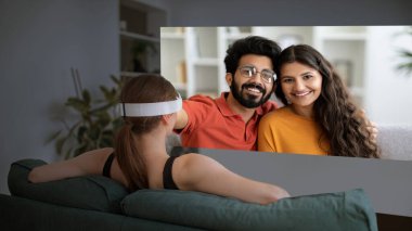 Video iletişimi. Sanal Gerçeklik Kulaklıklı Kadın, mutlu Hintli çiftle ekranda Modern Ev İçi Teknolojisi aracılığıyla iletişim kuruyor. Kolaj
