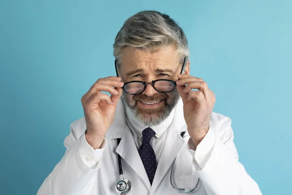 Σκεπτικός Και Αμφιβόλου Ώριμος Γκριζομάλλης Γενειοφόρος Γιατρός Προσαρμόζει Γυαλιά Του — Φωτογραφία Αρχείου