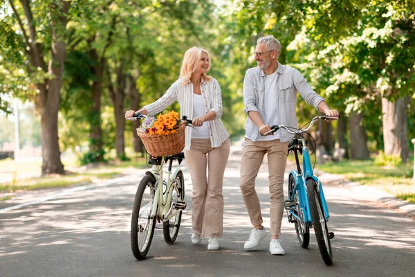 stock image Happy Senior Couple With Retro Bikes Walking Together In Summer Park, Cheerful Mature Husband And Wife Having Fun Outdoors, Enjoying Active Lifestyle On Retirement, Full Length, Copy Space