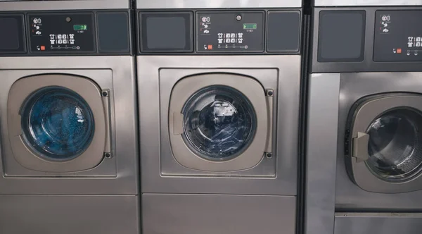 公共洗衣服务 三台工业用洗衣机安装在洗衣房的一排室内 洗涤剂设备和技术概念 — 图库照片