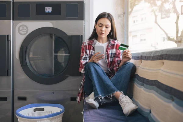 Young Lady Making Mobile Payment Laundry Room Menggunakan Phone Credit — Stok Foto