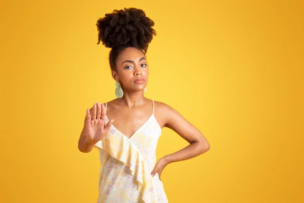 严肃而自信的千年非洲裔美国女人向摄像机伸出手来 没有拍照的痕迹 孤立在黄色的背景下 工作室 停止手势 广告和报价 — 图库照片