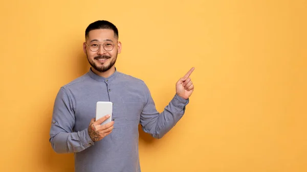 Specialerbjudande Porträtt Upphetsad Asiatisk Man Pekar Finger Sidan Kopiera Utrymme — Stockfoto