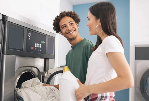 Happy Couple Putting Laundry Washing Machine Public Laundromat Interior Latin — Stock Photo, Image