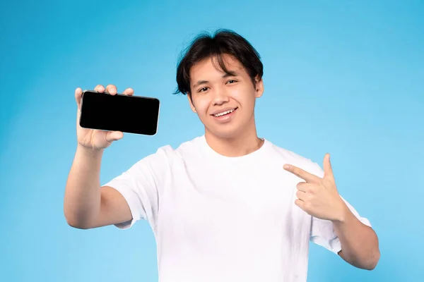 Χαμογελώντας Ασιάτης Φοιτητής Δείχνει Smartphone Δείχνοντας Δάχτυλο Στο Gadget Λευκή — Φωτογραφία Αρχείου