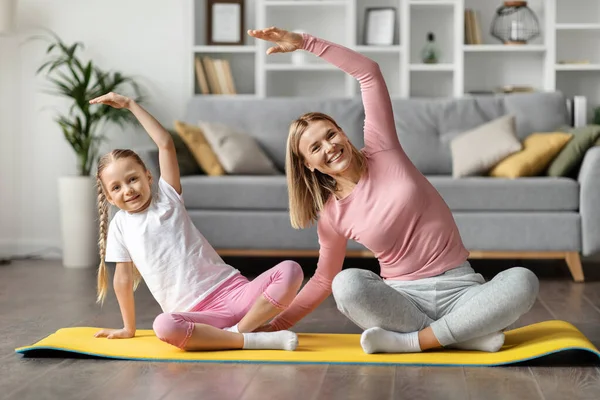 Happy Mother Daughter Making Seated Side Bend Stretch Exercise While — Stock Photo, Image