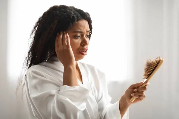 Zszokowany Czarny Kobieta Patrząc Szczotki Pełne Upadłych Włosów Podczas Robienia — Zdjęcie stockowe